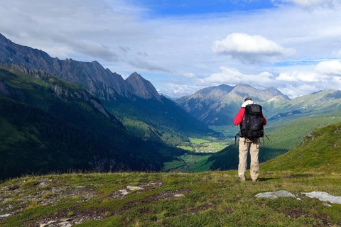 Hiker looking from the Pfitscherjoch into the Pfitschtal, Pfitsch, South Tyrol, Italy, Europe