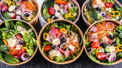 Round paper boxes with pre-packaged vegetable salads ready for sale