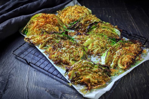 Baked savoy cabbage with parmesan cheese, honey and spices on baking sheet