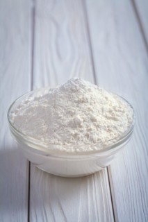 Flour in a bowl on an old painted wooden board