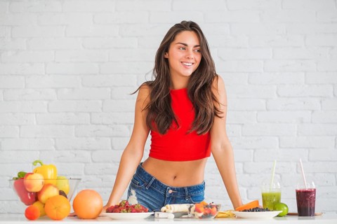 Happy young woman standing table with healthy food