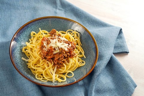 Spaghetti bolognese, pastsa with sauce from minced meat and tomatoes, garnished with parmesan on a