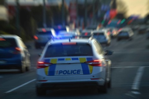 CHRISTCHURCH, NEW ZEALAND, AUGUST 30, 2022: A police car weaves through peak hour traffic on