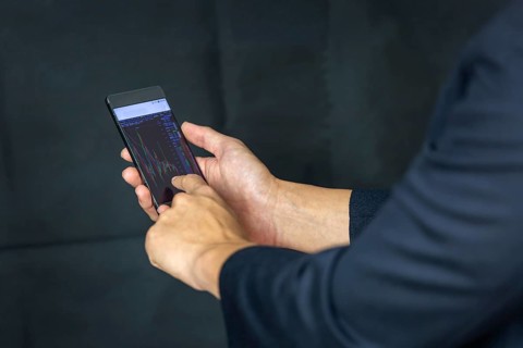 Stock Trader Looking At Stock Chart on Screen