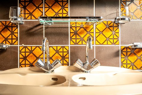 Retro and vintage bathroom sink, with mid century tiles, orange and brown colored