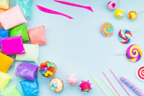 Colorful clay plastic bag with fake cake lollipop blue background