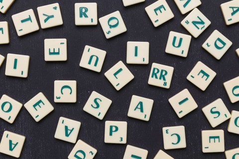 Close up scrabble letters against black background. High resolution photo