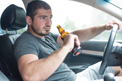 Man with beer driving car