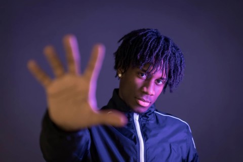 Black person doing the stop racism gesture on a black background