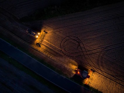 A combine harvester harvests a grain forest. When it is harvest time, the grain must also be