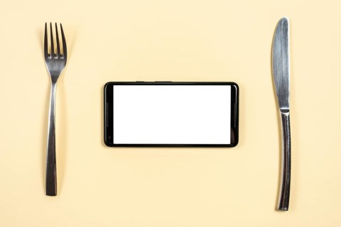 Smartphone stainless steel fork butterknife beige background