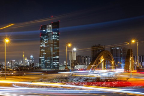 The lights of the European Central Bank (ECB) and the Frankfurt banking skyline glow in the