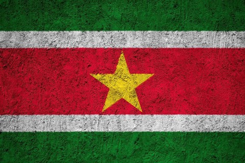 Suriname Flag painted on the cracked grunge concrete wall