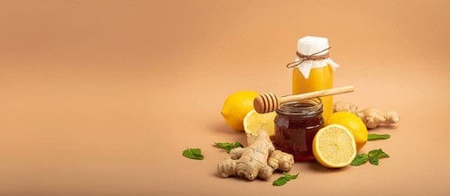 Composition with detox drink, sea buckthorn berries, lemons, mint, ginger, honey in glass jar. Food