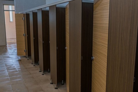 Wood grain doors to toilet stalls in men's public restroom in South Korea