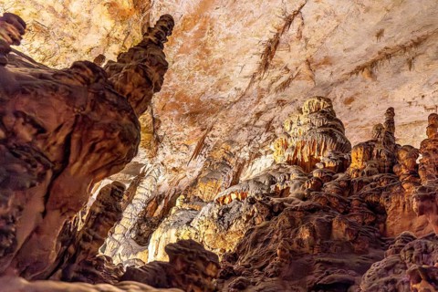 Majestic stalactites and stalagmites create a breathtaking spectacle in the illuminated caverns of
