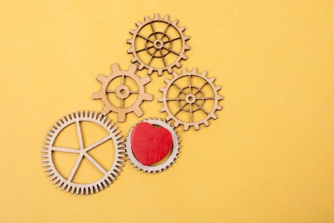 Heart shaped icon and Wooden cogwheels as love concepts