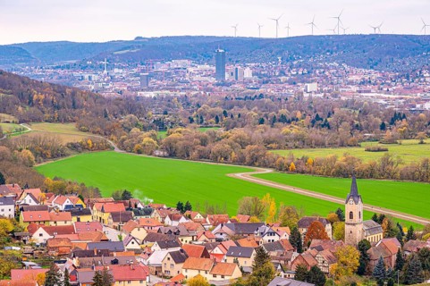 Village in the valley with Jena and wind turbines in the background, surrounded by autumnal