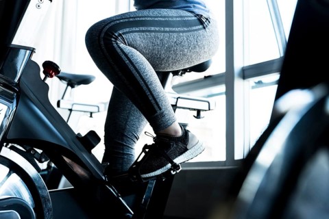 Fitness girl using stationary bike