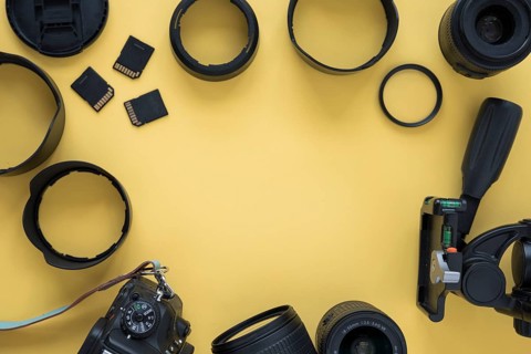 Professional dslr modern camera with camera accessories yellow background