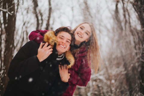 Beautiful young teen couple spending time together outside in cold winter. Happy and joyful people