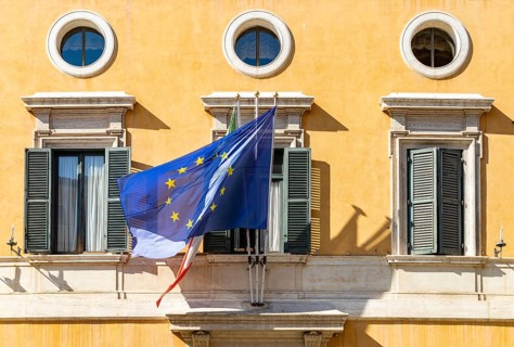 A picture of the Italian and European Union flags on a building facade