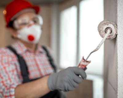 Female construction worker with helmet paint roller