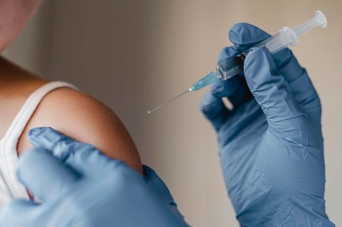 Doctor with gloves administering little child vaccine