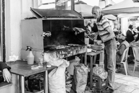 Man put Souvlaki on a charcoal barbecue in the village Tymbaki in south-central Crete. Saturday is