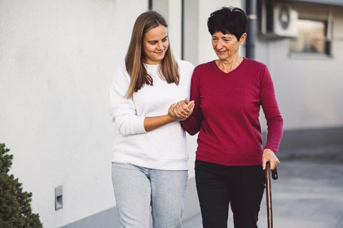 Young caucasian woman a nurse, on a home visit taking care of a senior lady. Nurse helping a senior