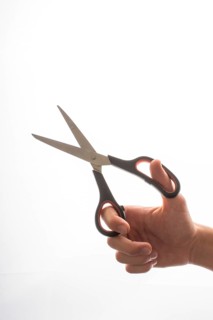 Hand holding steel scissors on a white backgruond