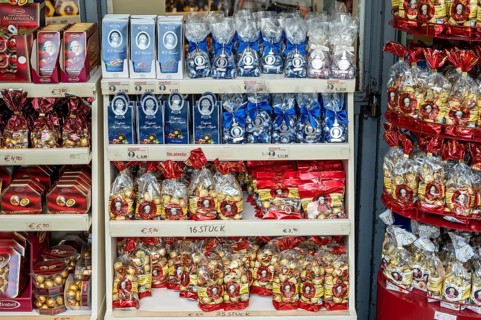 Shelves full of packaged chocolates and sweets in a shop with price labels, Mozartkugeln, Salzburg,