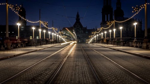 Dark, evening street view with light traces of a tram and illuminated architecture in the