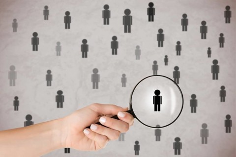 Concept of Human Resources selection. Hand holding loupe selecting a candidate
