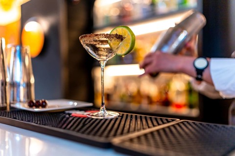 Unrecognizable bartender preparing a luxury cocktail in a martini glass in a night club