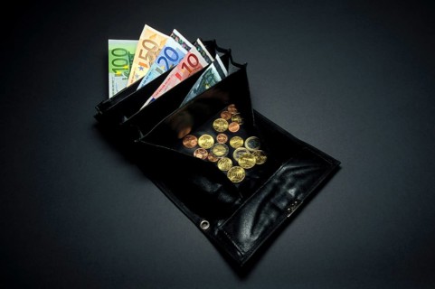 Closeup of a black waiter purse or wallet, small or loose change coins of Euros and Cents, a 5, 10,