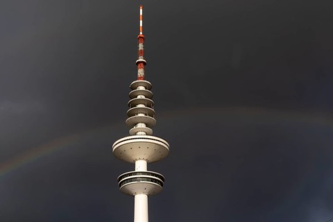 Weather symbol, Telemichel TV tower in front of a dramatic stormy sky with rainbow, Hamburg,