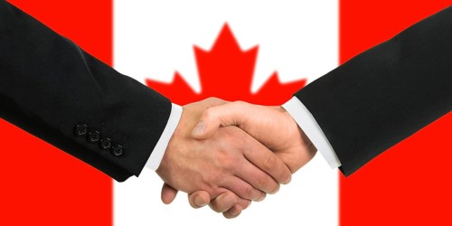 The Canadian flag and business handshake