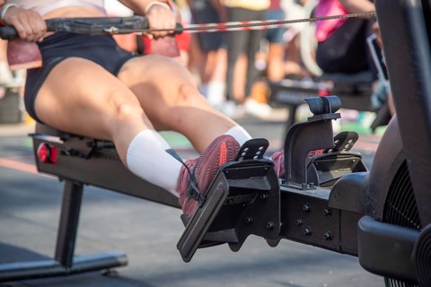 Close-up of a person using a rowing machine in the outdoor gym, focusing on his legs, Barcelona,