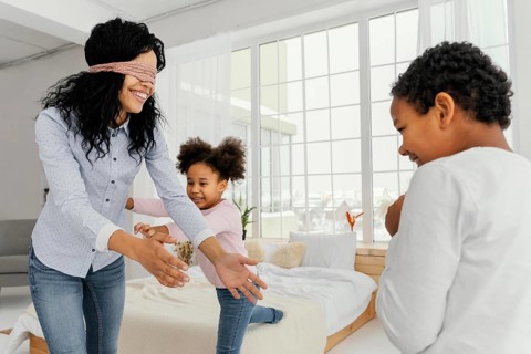 Smiley mother playing with her children home