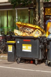 Overfilled waste containers for lightweight packaging standing on the street, Germany, Europe