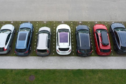 Bird's eye view of a car park with cars in front of a hotel in the town of Kolobrzeg in Poland