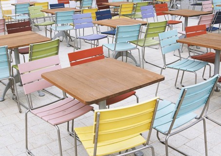 empty deserted street cafe or outdoor restaurant tables with multicolored chairs - off season or