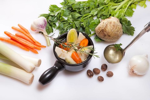 Ingredients for fresh vegetarian vegetable stock, leek, carrots, garlic, celery, onions, nutmeg,