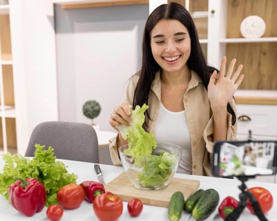 Female vlogging home with smartphone vegetables