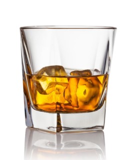Glass of scotch whiskey and ice on a white background