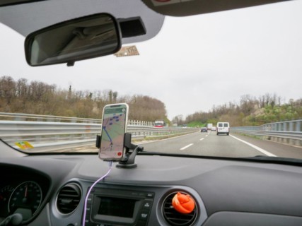 View from inside a car with a smartphone navigation setup driving on a highway, A1 A8 highway near