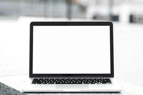 Open laptop showing blank white screen display bench against blurred background. High resolution
