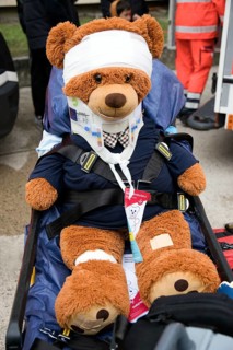 Injured teddy bear with full care sits on a rescue stretcher, police, open day, Berlin, Germany,
