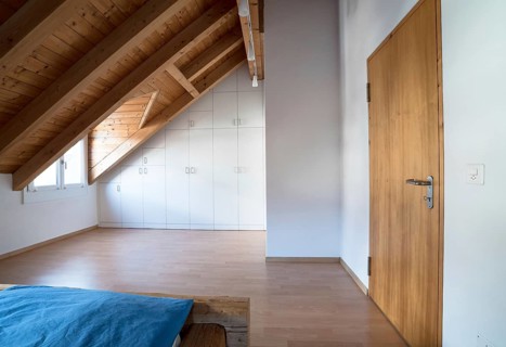 horizontal view of a bright light modern simple master bedroom with wooden parquet floors and